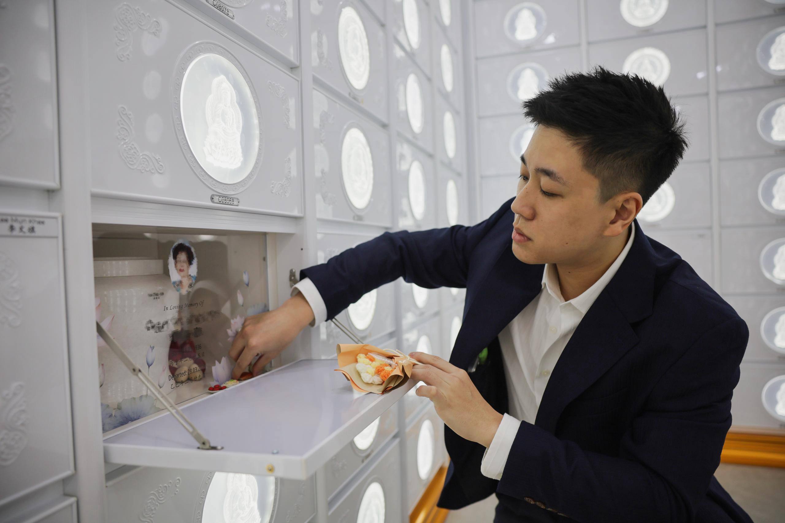 Kenneth Yeow arranging flowers at a columbarium niche